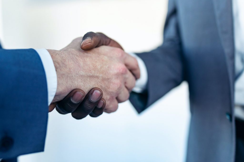 Close-up view of business partner handshaking process.
